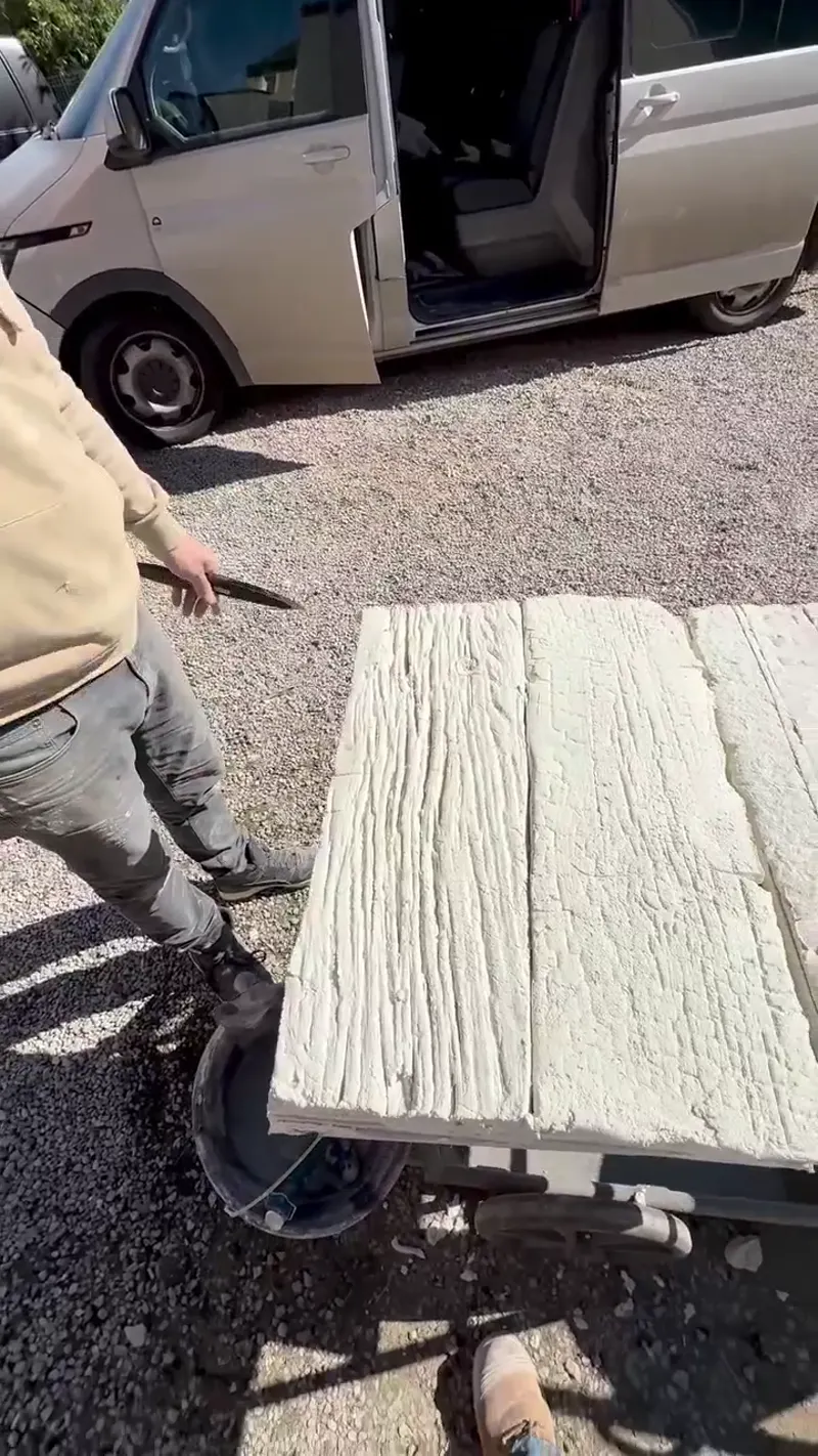 Panneau en imitation pierre blanc transporté sur chantier