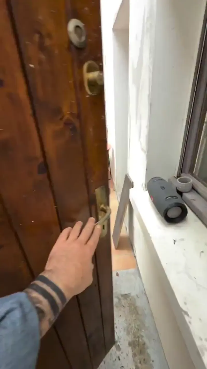 L'artisan applique un enduit à la taloche sur une façade extérieure