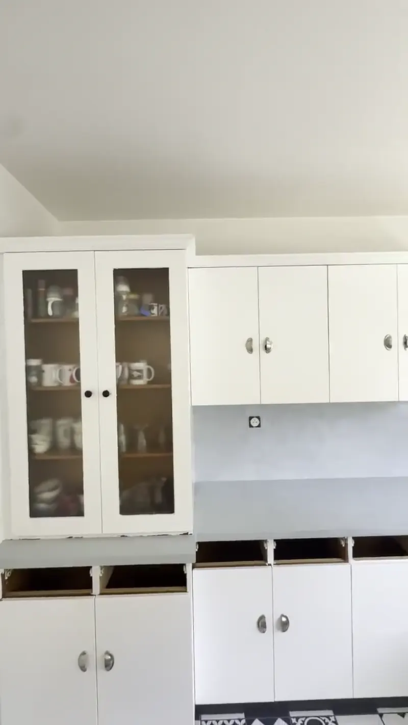 Crédence en béton ciré gris dans une cuisine aux meubles blancs