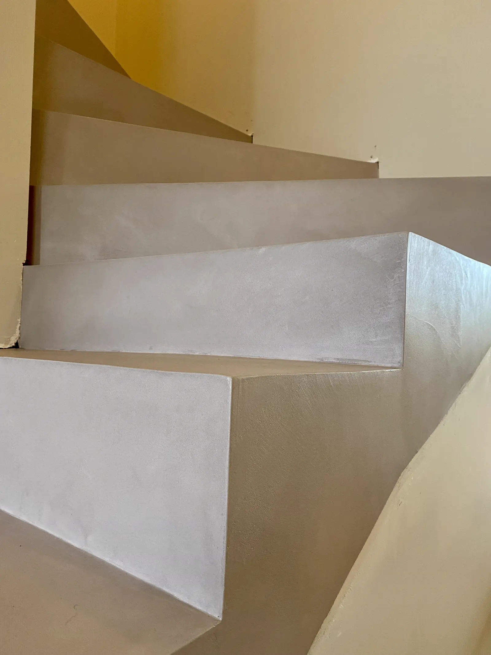 Escalier en béton ciré crème avec sol en parquet foncé