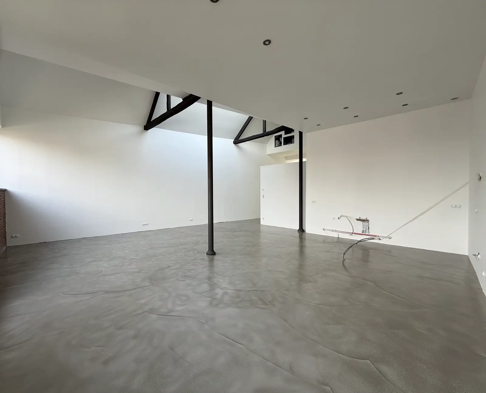 Grande pièce vide avec sol en béton ciré gris à la texture patinée