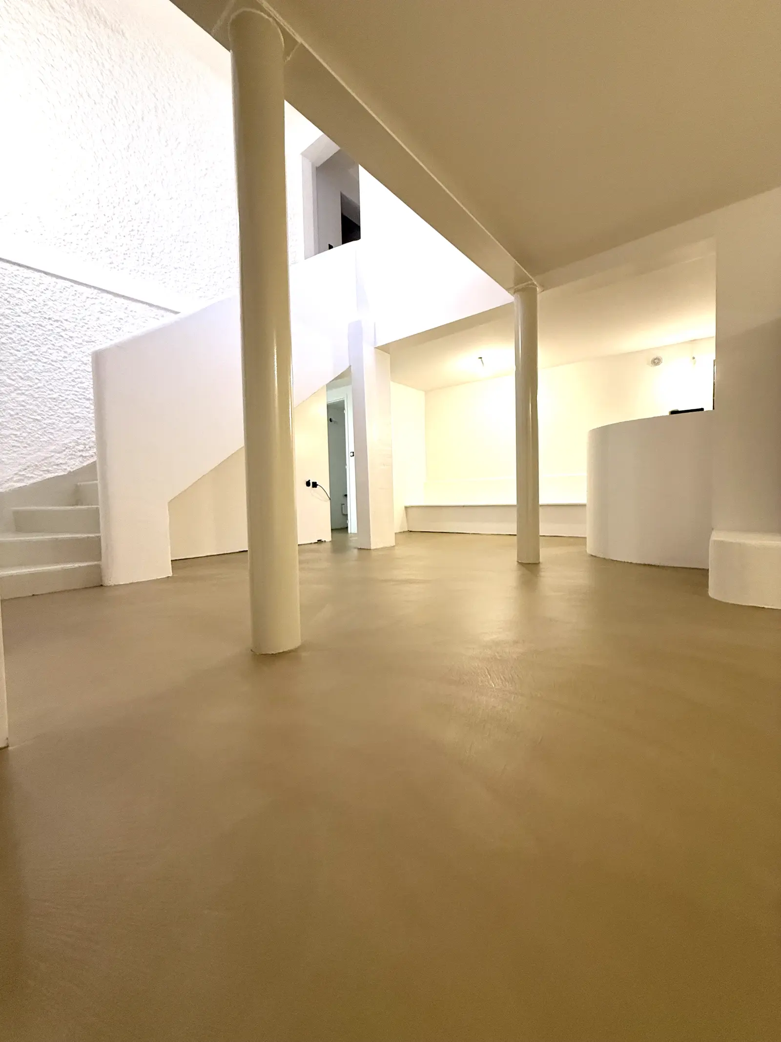Pièce avec sol en béton ciré beige et colonnes