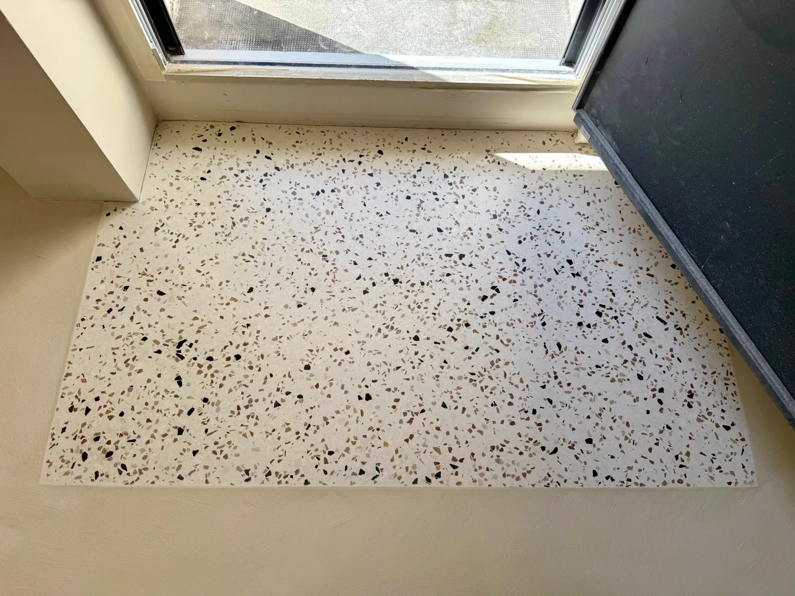 Sol en terrazzo en chantier, escalier en bois visible en arrière-plan