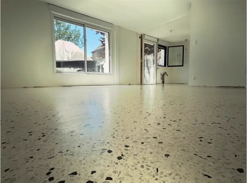 Sol en terrazzo clair dans une pièce vide avec fenêtre