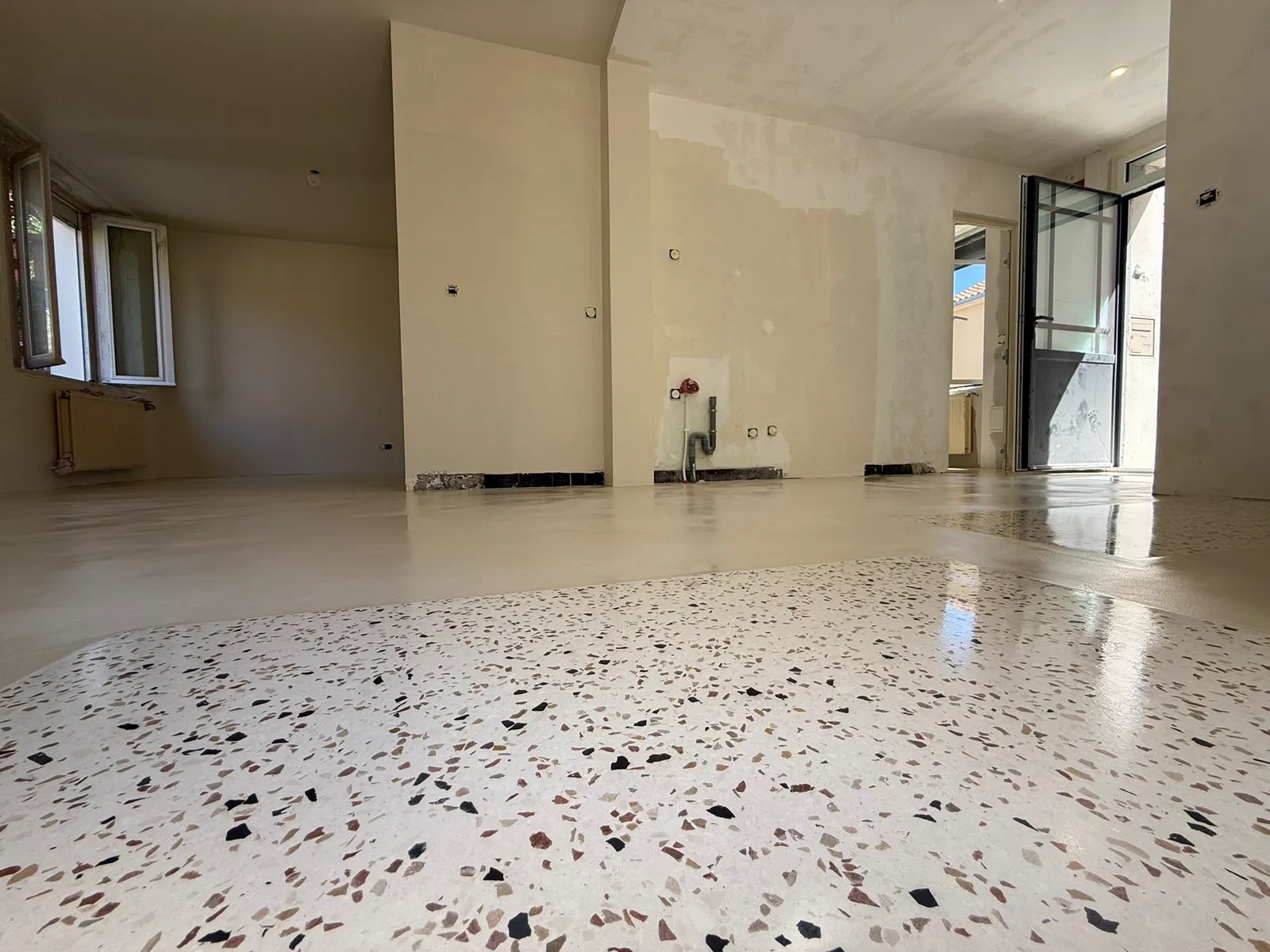Sol en terrazzo clair, vue large d'une pièce